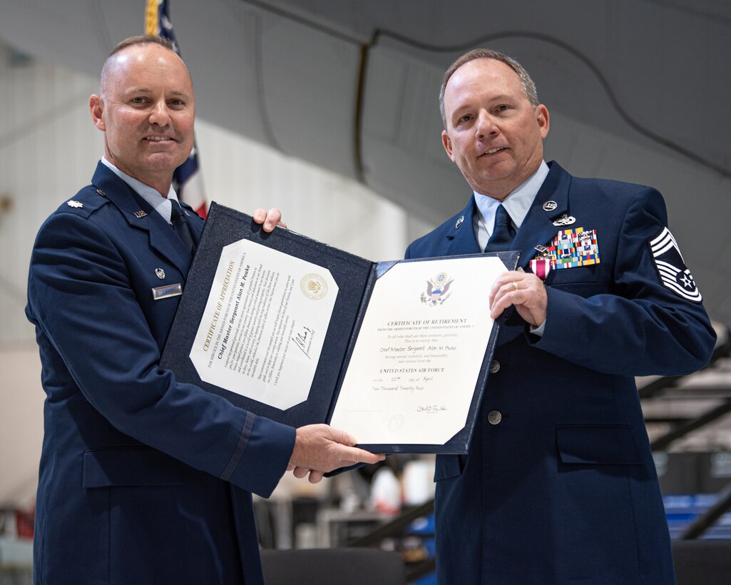 Lt. Col. James Embry, left, commander of the 123rd Aircraft Maintenance Squadron, presents a certificate of retirement to Chief Master Sgt. Alan Peake during a ceremony at the Kentucky Air National Guard Base in Louisville, Ky., Apr. 21, 2024. Peake retired as the maintenance production superintendent for the 123rd Aircraft Maintenance Squadron after more than 36 years of service. (U.S. Air National Guard photo by Staff Sgt. Chloe Ochs)