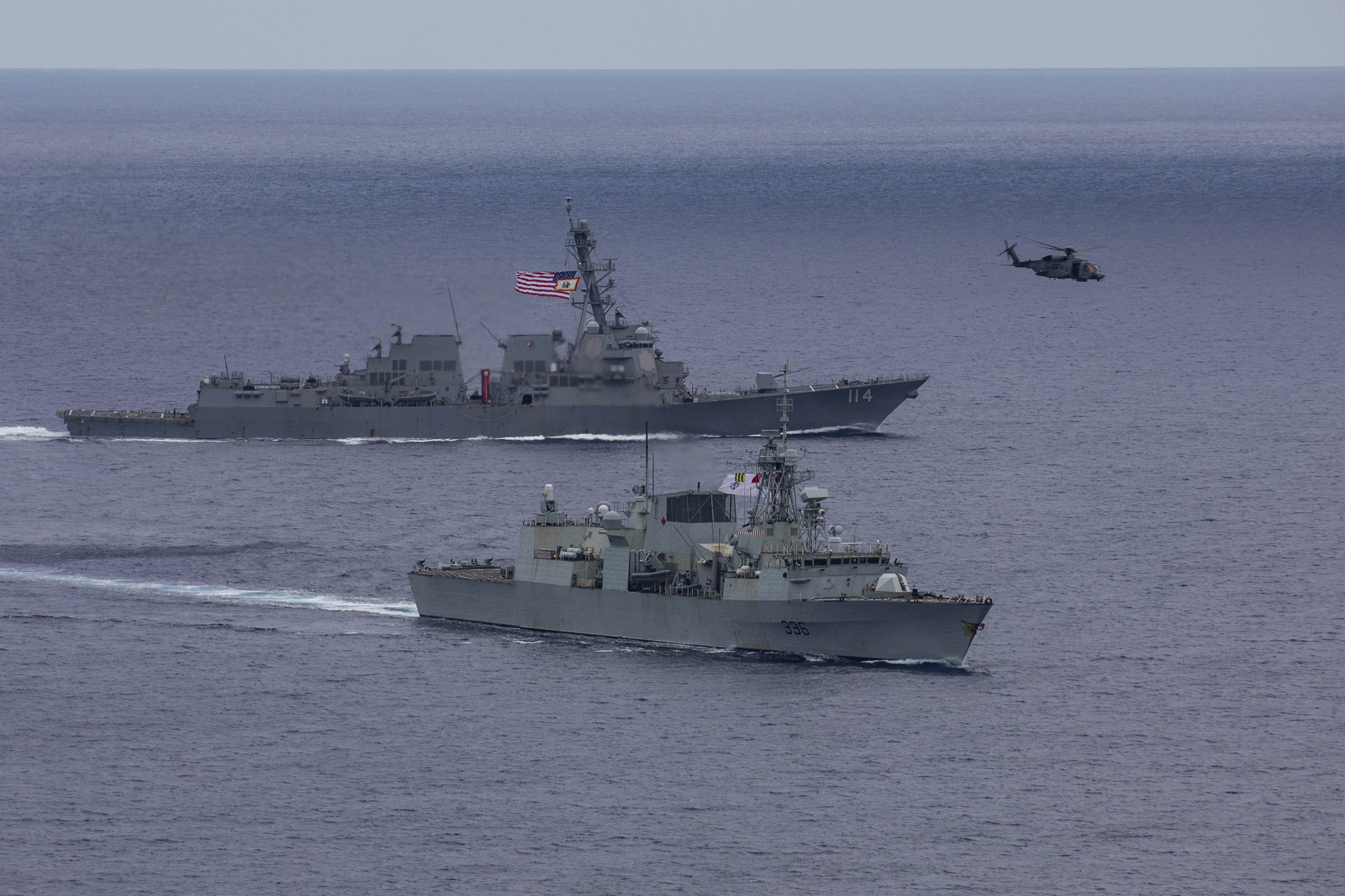 240618-N-HT008-1821 SOUTH CHINA SEA (June 18, 2024) The Arleigh Burke-class guided-missile destroyer USS Ralph Johnson (DDG 114), left, conducts bilateral operations with Royal Canadian Navy Halifax-class frigate HMCS Montreal (FFH 336) in the South China Sea, June 18, 2024. Combined operations such as this are intended to improve interoperability between allied navies and support a free and open Indo-Pacific. Ralph Johnson is forward deployed and assigned to Destroyer Squadron (DESRON) 15, the Navy’s largest DESRON and the U.S. 7th fleet’s principal surface force. (U.S. Navy photo by Mass Communication Specialist Seaman Trevor Hale)