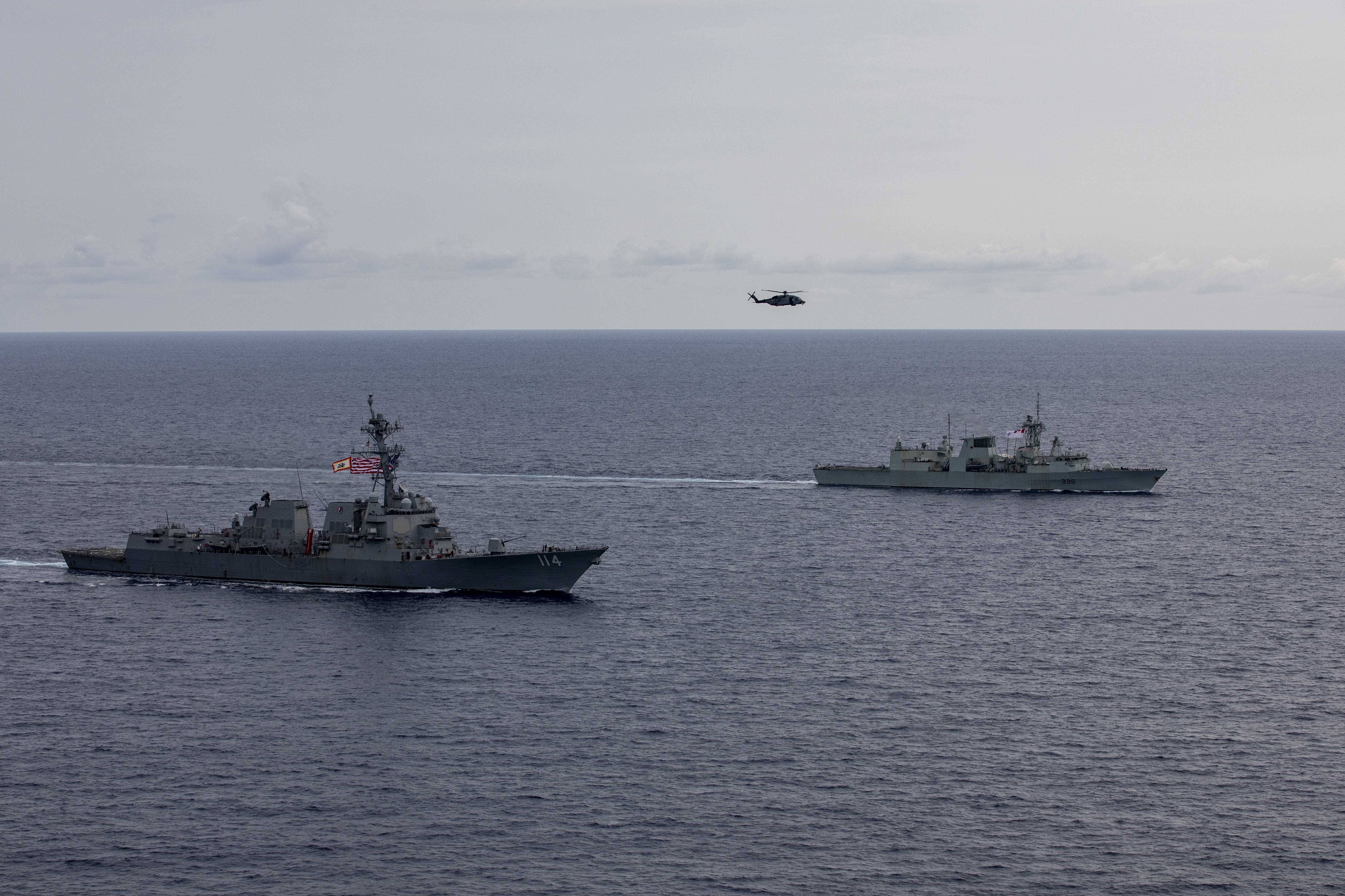 240618-N-HT008-2112 SOUTH CHINA SEA (June 18, 2024) The Arleigh Burke-class guided-missile destroyer USS Ralph Johnson (DDG 114), left, conducts bilateral operations with Royal Canadian Navy Halifax-class frigate HMCS Montreal (FFH 336) in the South China Sea, June 18, 2024. Combined operations such as this are intended to improve interoperability between allied navies and support a free and open Indo-Pacific. Ralph Johnson is forward deployed and assigned to Destroyer Squadron (DESRON) 15, the Navy’s largest DESRON and the U.S. 7th fleet’s principal surface force. (U.S. Navy photo by Mass Communication Specialist Seaman Trevor Hale)