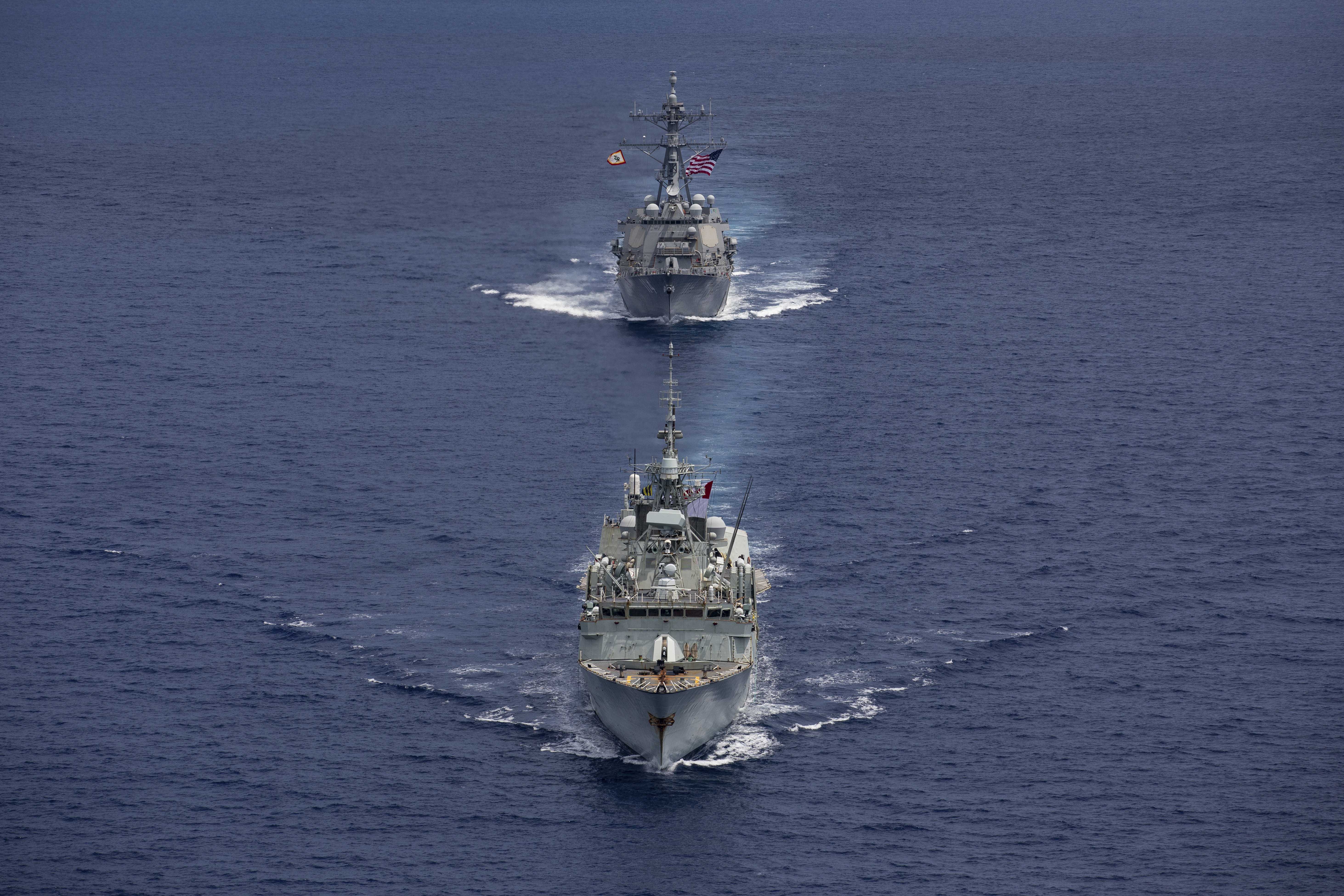 240618-N-HT008-1519 SOUTH CHINA SEA (June 18, 2024) The Arleigh Burke-class guided-missile destroyer USS Ralph Johnson (DDG 114), top, conducts bilateral operations with Royal Canadian Navy Halifax-class frigate HMCS Montreal (FFH 336) in the South China Sea, June 18, 2024. Combined operations such as this are intended to improve interoperability between allied navies and support a free and open Indo-Pacific. Ralph Johnson is forward deployed and assigned to Destroyer Squadron (DESRON) 15, the Navy’s largest DESRON and the U.S. 7th fleet’s principal surface force. (U.S. Navy photo by Mass Communication Specialist Seaman Trevor Hale)