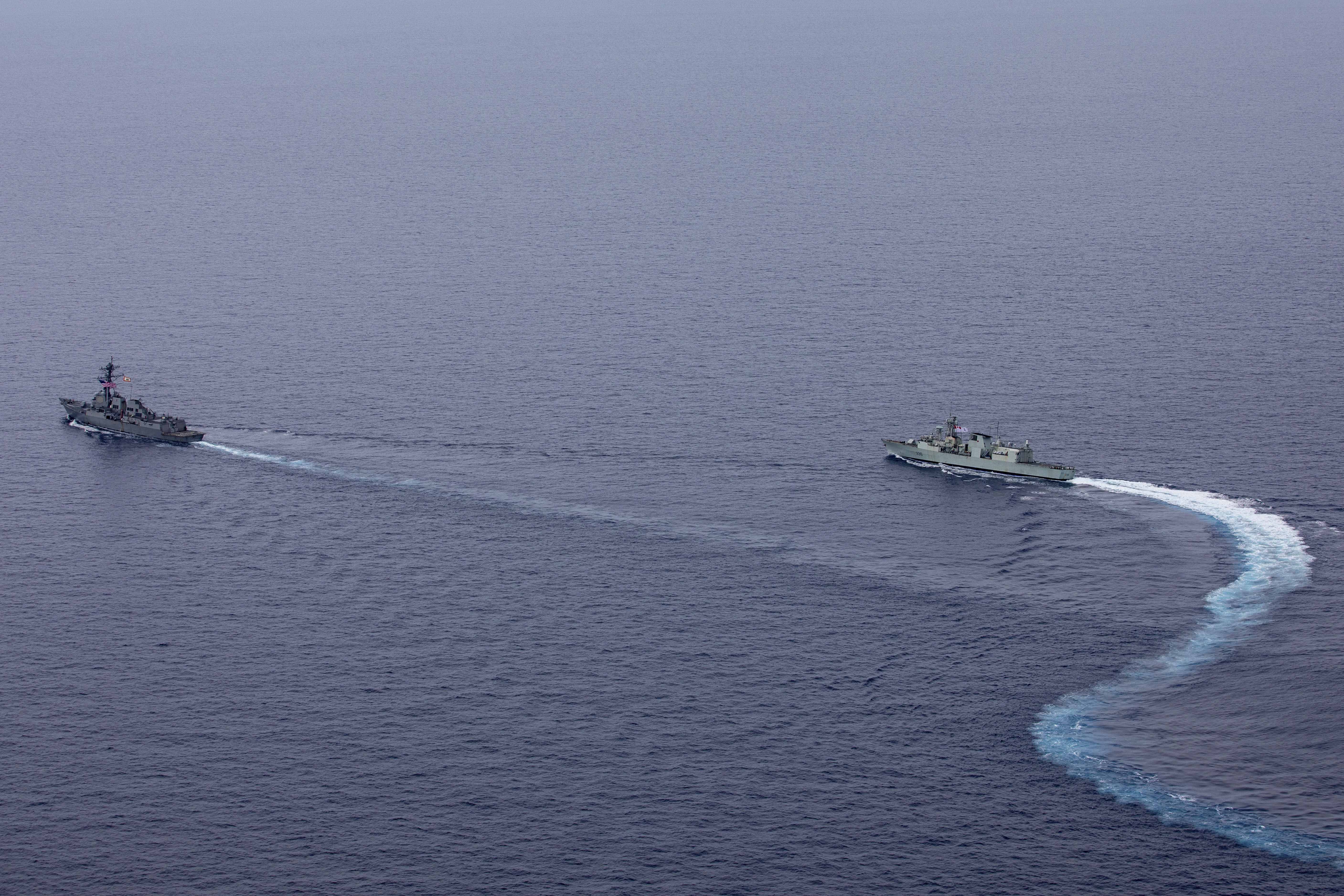 240618-N-HT008-2176 SOUTH CHINA SEA (June 18, 2024) The Arleigh Burke-class guided-missile destroyer USS Ralph Johnson (DDG 114), left, conducts bilateral operations with Royal Canadian Navy Halifax-class frigate HMCS Montreal (FFH 336) in the South China Sea, June 18, 2024. Combined operations such as this are intended to improve interoperability between allied navies and support a free and open Indo-Pacific. Ralph Johnson is forward deployed and assigned to Destroyer Squadron (DESRON) 15, the Navy’s largest DESRON and the U.S. 7th fleet’s principal surface force. (U.S. Navy photo by Mass Communication Specialist Seaman Trevor Hale)