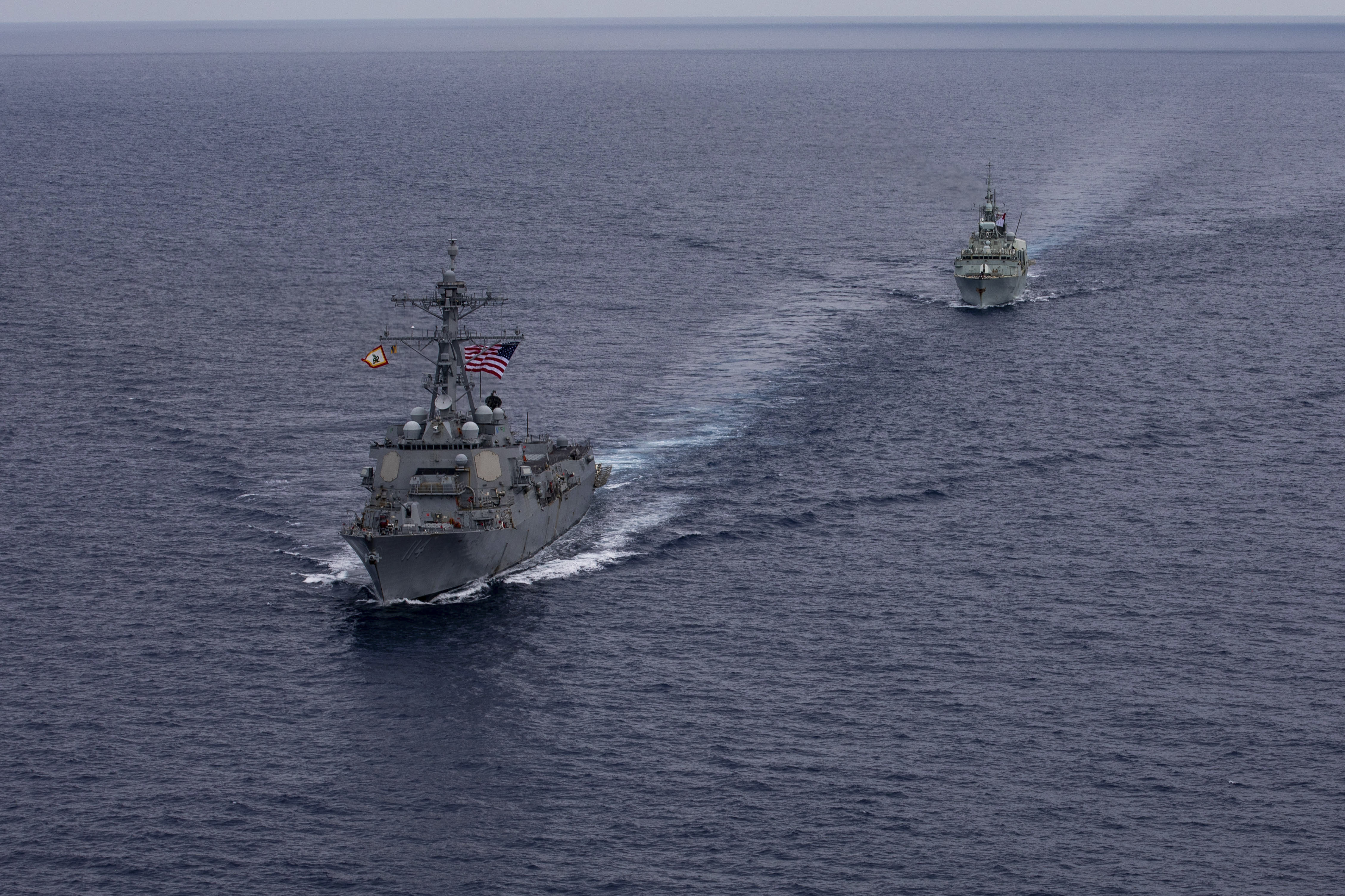240618-N-HT008-2027 SOUTH CHINA SEA (June 18, 2024) The Arleigh Burke-class guided-missile destroyer USS Ralph Johnson (DDG 114), left, conducts bilateral operations with Royal Canadian Navy Halifax-class frigate HMCS Montreal (FFH 336) in the South China Sea, June 18, 2024. Combined operations such as this are intended to improve interoperability between allied navies and support a free and open Indo-Pacific. Ralph Johnson is forward deployed and assigned to Destroyer Squadron (DESRON) 15, the Navy’s largest DESRON and the U.S. 7th fleet’s principal surface force. (U.S. Navy photo by Mass Communication Specialist Seaman Trevor Hale)