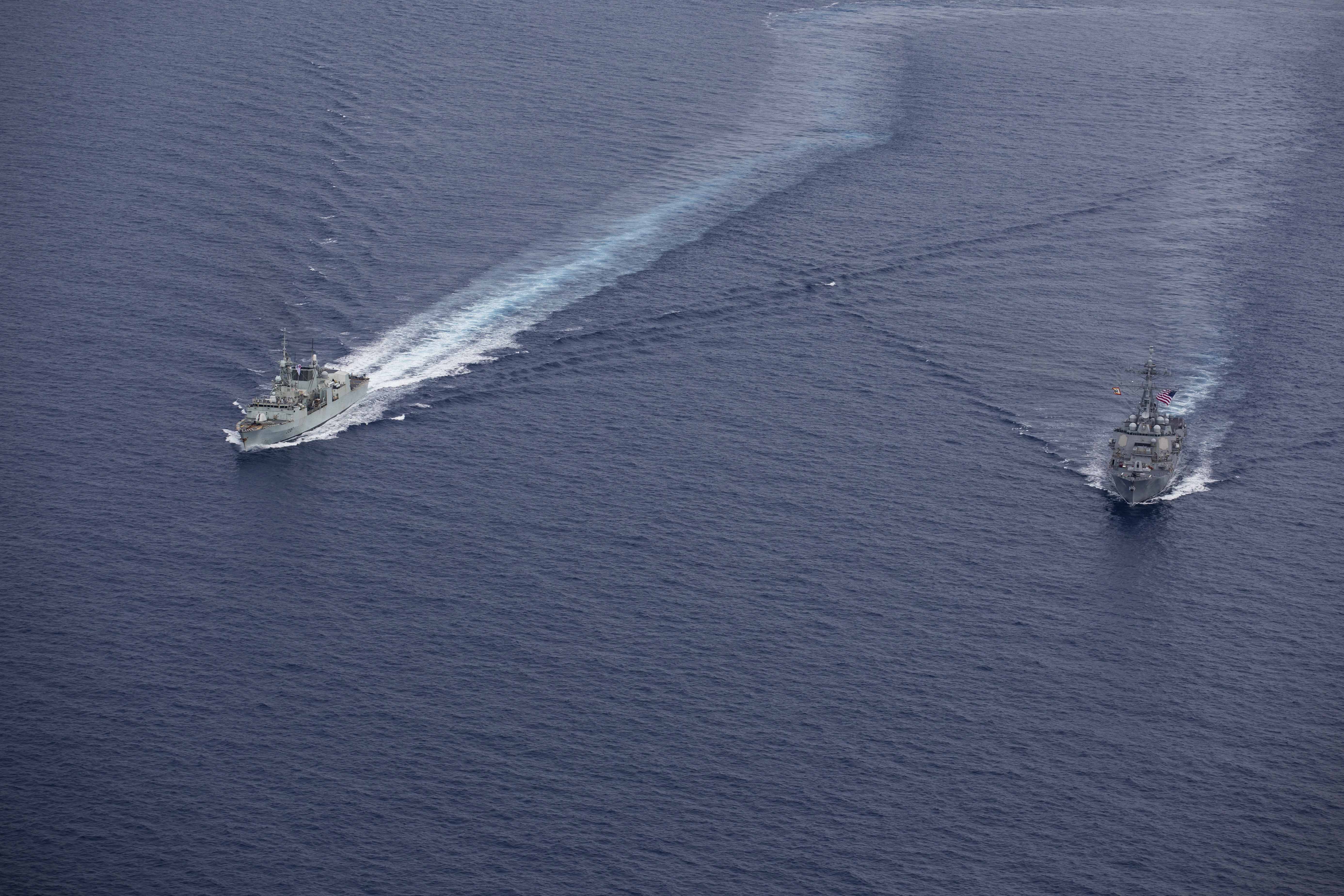 240618-N-HT008-2197 SOUTH CHINA SEA (June 18, 2024) The Arleigh Burke-class guided-missile destroyer USS Ralph Johnson (DDG 114), right, conducts bilateral operations with Royal Canadian Navy Halifax-class frigate HMCS Montreal (FFH 336) in the South China Sea, June 18, 2024. Combined operations such as this are intended to improve interoperability between allied navies and support a free and open Indo-Pacific. Ralph Johnson is forward deployed and assigned to Destroyer Squadron (DESRON) 15, the Navy’s largest DESRON and the U.S. 7th fleet’s principal surface force. (U.S. Navy photo by Mass Communication Specialist Seaman Trevor Hale)
