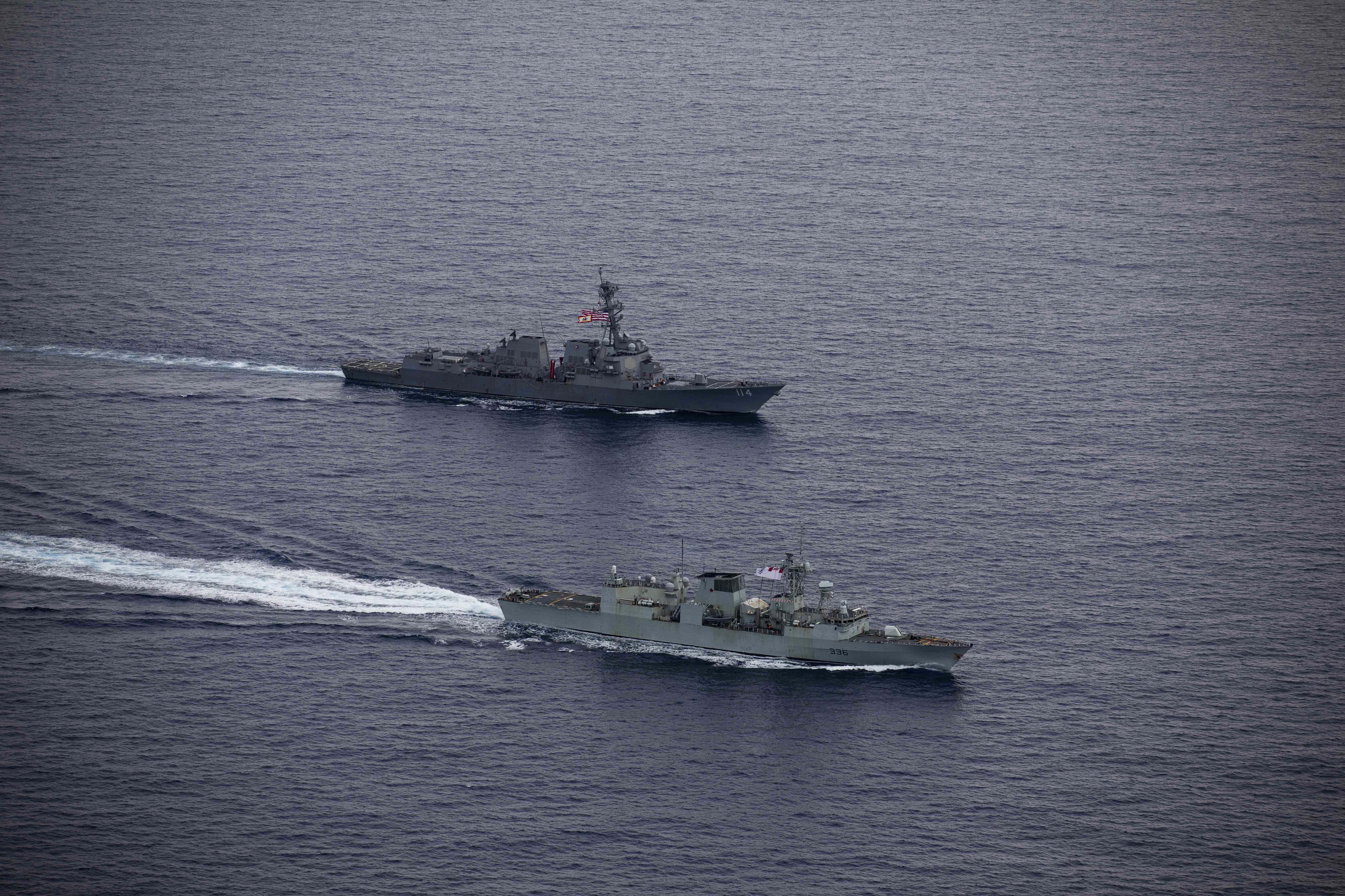 240618-N-HT008-2220 SOUTH CHINA SEA (June 18, 2024) The Arleigh Burke-class guided-missile destroyer USS Ralph Johnson (DDG 114), top, conducts bilateral operations with Royal Canadian Navy Halifax-class frigate HMCS Montreal (FFH 336) in the South China Sea, June 18, 2024. Combined operations such as this are intended to improve interoperability between allied navies and support a free and open Indo-Pacific. Ralph Johnson is forward deployed and assigned to Destroyer Squadron (DESRON) 15, the Navy’s largest DESRON and the U.S. 7th fleet’s principal surface force. (U.S. Navy photo by Mass Communication Specialist Seaman Trevor Hale)