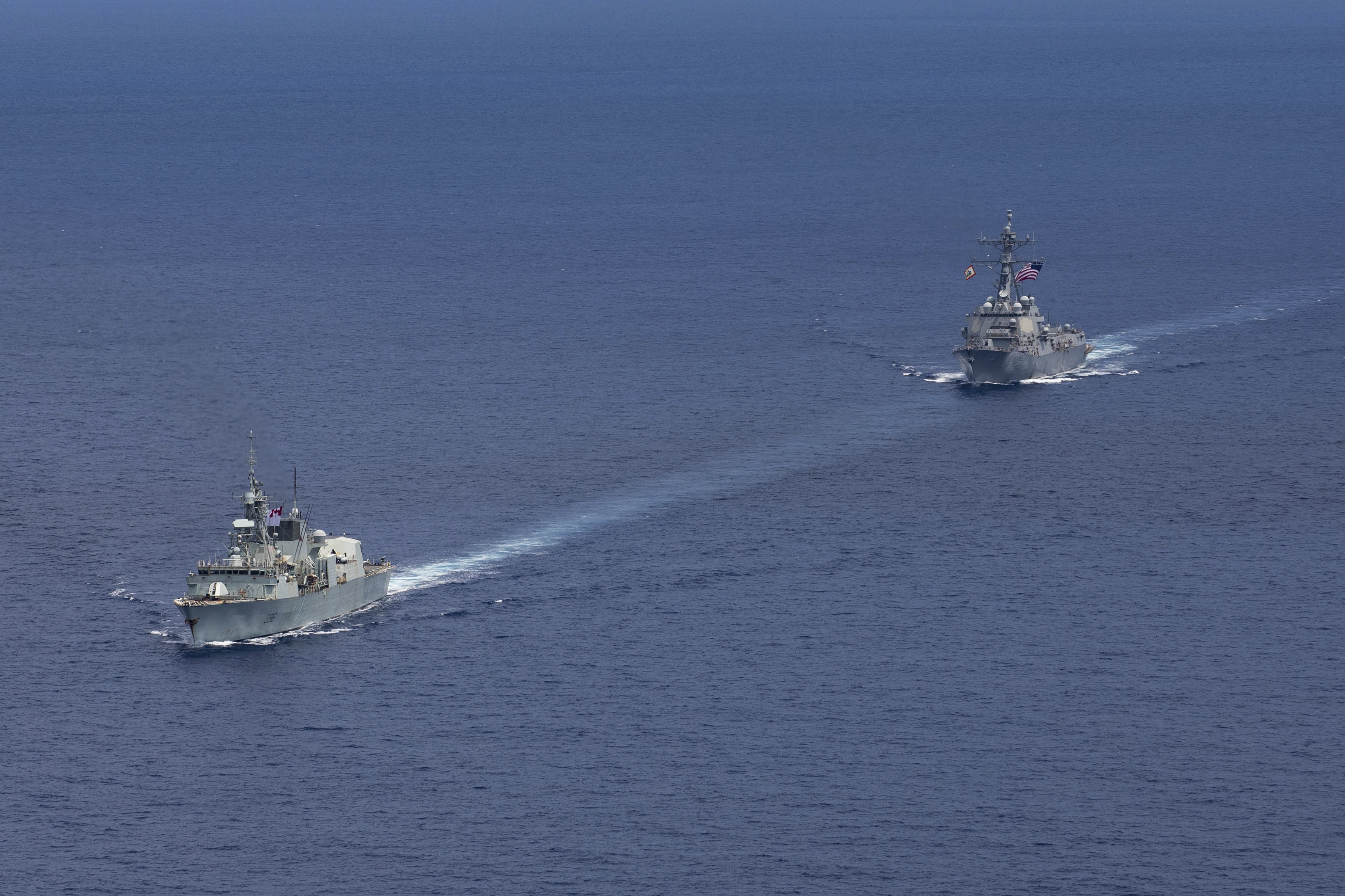 240618-N-HT008-1461 SOUTH CHINA SEA (June 18, 2024) The Arleigh Burke-class guided-missile destroyer USS Ralph Johnson (DDG 114), right, conducts bilateral operations with Royal Canadian Navy Halifax-class frigate HMCS Montreal (FFH 336) in the South China Sea, June 18, 2024. Combined operations such as this are intended to improve interoperability between allied navies and support a free and open Indo-Pacific. Ralph Johnson is forward deployed and assigned to Destroyer Squadron (DESRON) 15, the Navy’s largest DESRON and the U.S. 7th fleet’s principal surface force. (U.S. Navy photo by Mass Communication Specialist Seaman Trevor Hale)