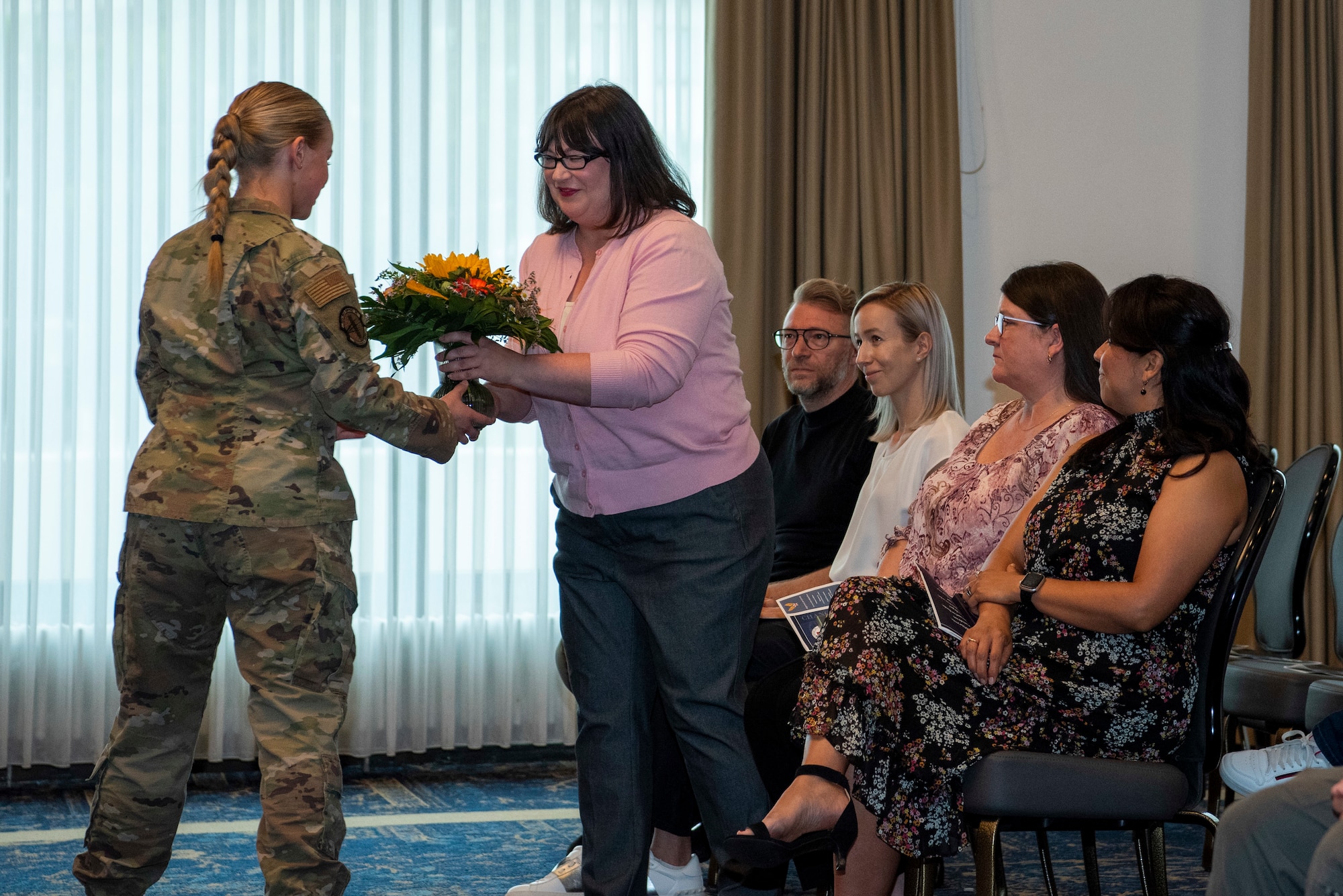 Airman hands woman flowers