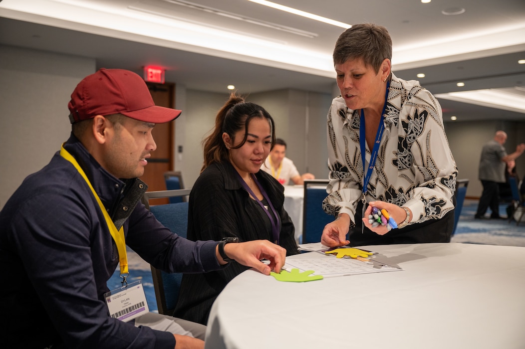 Photo of a person handingout paper hands to a couple.