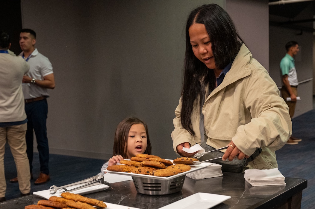 Photo of a woman and her child getting cookies out of a bowl.