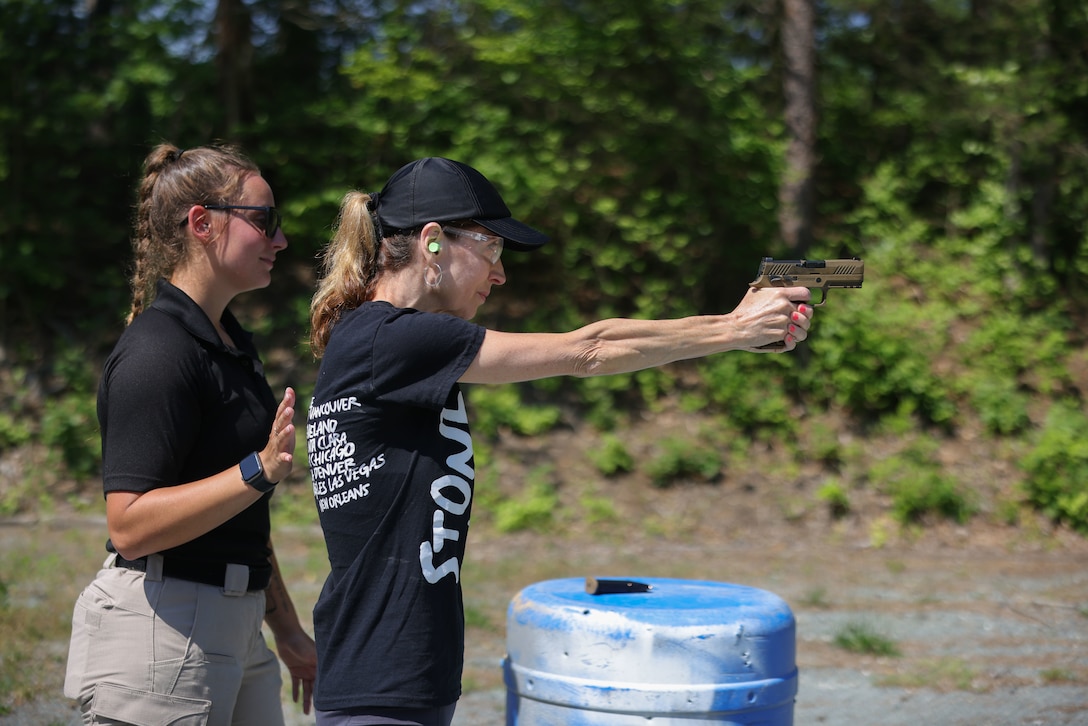 Amy Aldridge, coordinator of experiential learning at Southeast Missouri State University, sights in down range while supervised by U.S. Marine Corps Cpl. Nayomi Koepke, a member of the Marine Corps Shooting Team during a range at the Educators Workshop on Marine Corps Base Quantico, Va., June 13, 2024. The workshop enables MCRC to spread awareness of the Marine Corps' purpose, values and service opportunities to those educators who are engaged in supporting the future of their students. (U.S. Marine Corps photo by Lance Cpl. Brenna Ritchie)