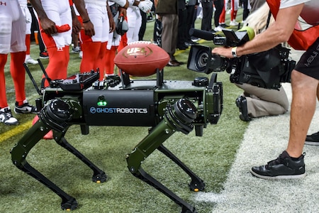 Army robotic dog holds a football.