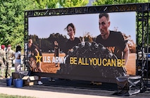 People gaze at a large Army video display.