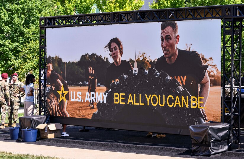 People gaze at a large Army video display.
