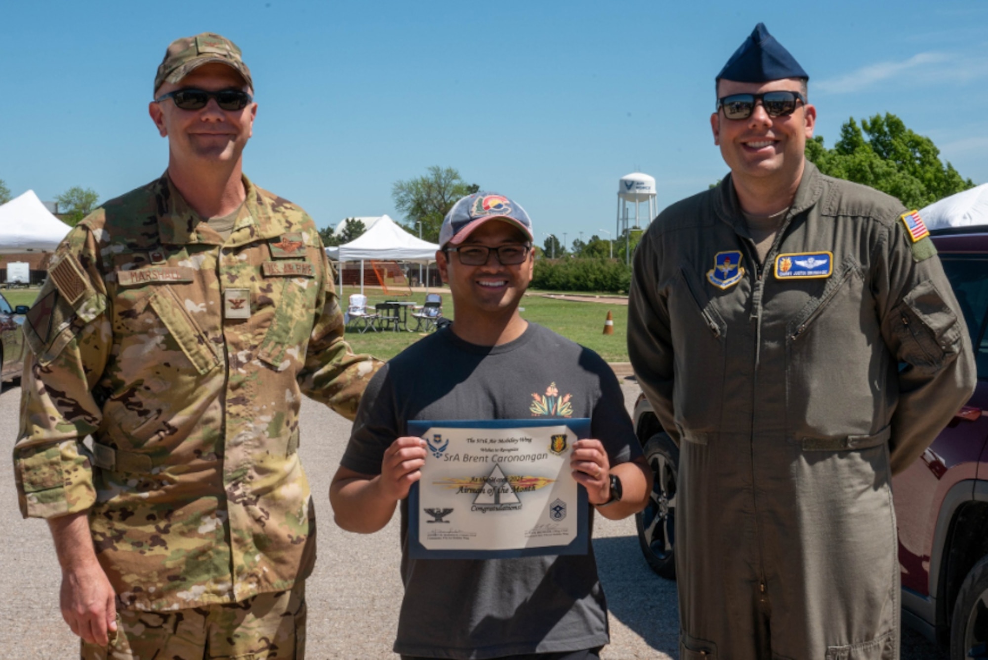U.S. Air Force Senior Airman Brent Caronongan, 97th Force Support Squadron food services a.m. shift leader, poses for a photo with Col. Jeff Marshall, 97th Air Mobility Wing (AMW) commander, and Chief Master Sgt. Justin Brundage, 97th AMW command chief, at Altus Air Force Base, Oklahoma, May 10, 2024. Caronongan won Airman of the Month in March 2024 by going above and beyond his typical duties. (U.S. Air Force photo by Airman 1st Class Heidi Bucins)
