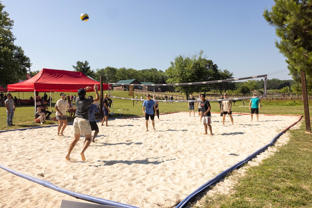 U.S. Marines with Security Battalion play volley ball during a family day event at Lunga Park, Quantico, Virginia on June 14, 2024. The event hosted the unit’s Marines and family members to build unit cohesion and comradery through games, food and drinks, and other various resource vendors to promote healthy lifestyles. (U.S. Marine Corps photo by Cpl. Darien Wright)