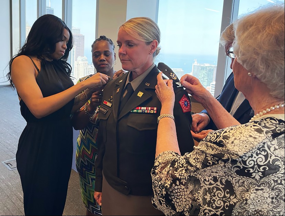 Gold Star daughter Nyzia Wilson pins colonel rank on Beth Roxworthy during her promotion ceremony.