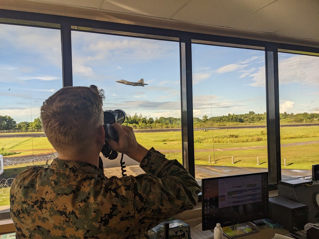Sgt. Colby Pedersen, an air traffic controller with the Marine Air Control Squadron 1 Marine Air Traffic Control Mobile Team (MMT), Marine Air Control Group 38, 3rd Marine Aircraft Wing, controls an F-22 Raptor with the U.S. Air Force 27th Fighter Squadron, as it conducts a low approach onto Runway 09 at Palau International Airport, Arai, Palau, June 12, 2024. Marines with the MMT provided Federal Aviation Administration certified tower and ground control to Palau International Airport in support of exercise Valiant Shield 24, June 7-18, 2024, providing air traffic control services to 214 military and civilian aircraft.