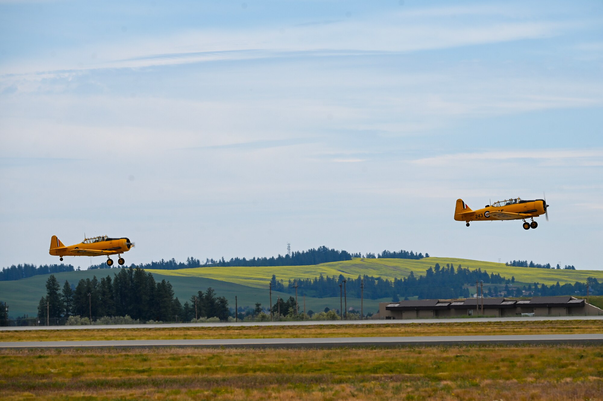 Two AT-6 aircrafts take off from the flightline.