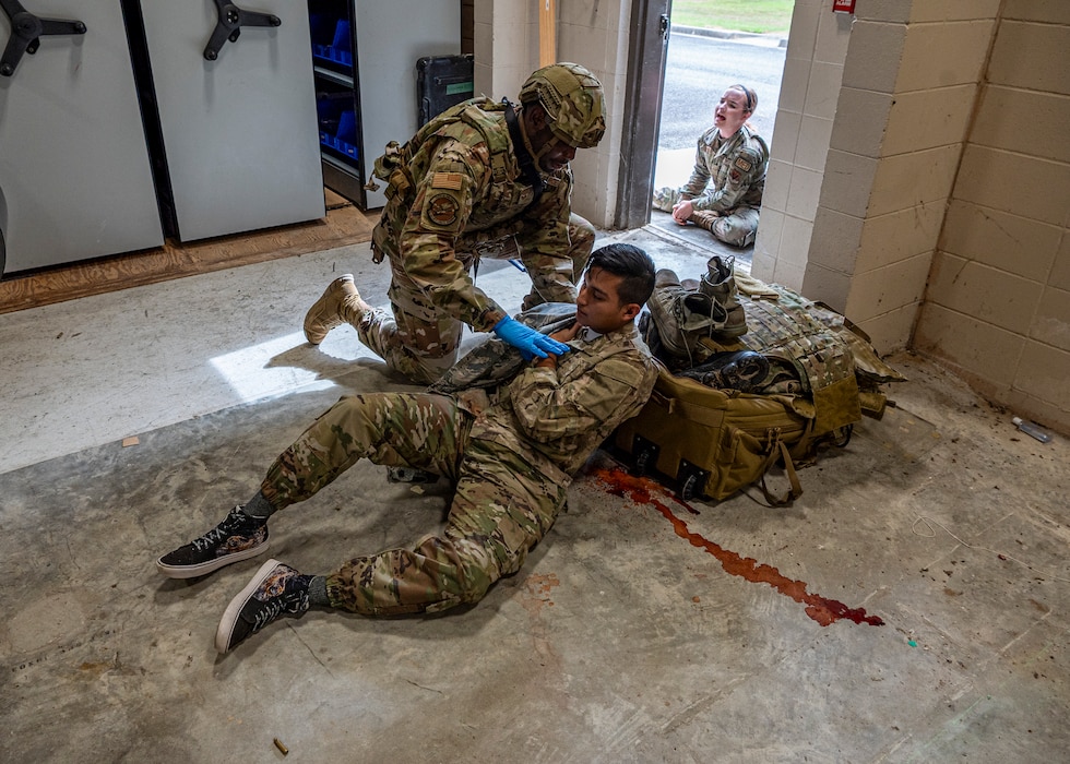 An Airman assigned to the 23rd Security Forces Squadron helps a simulated gunshot victim at Moody Air Force Base, Georgia, June 20, 2024. Once the simulated active shooter was neutralized, security forces Airmen provided aid to the victims before the paramedics arrived on scene. The goal of the exercise was to assess and improve base personnel and security forces’ actions and response to an active shooter incident. (U.S. Air Force photo by Airman 1st Class Leonid Soubbotine)