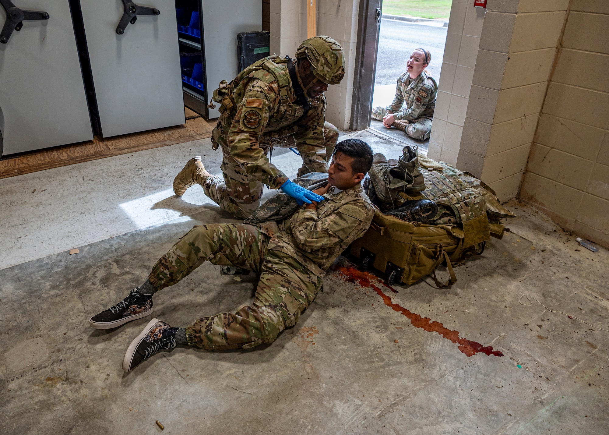 An Airman assigned to the 23rd Security Forces Squadron helps a simulated gunshot victim at Moody Air Force Base, Georgia, June 20, 2024. Once the simulated active shooter was neutralized, security forces Airmen provided aid to the victims before the paramedics arrived on scene. The goal of the exercise was to assess and improve base personnel and security forces’ actions and response to an active shooter incident. (U.S. Air Force photo by Airman 1st Class Leonid Soubbotine)
