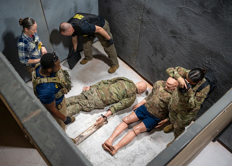 U.S. Air Force Tech. Sgt. Jessica Smith-McMahan, 23rd Wing Public Affairs community relations noncommissioned officer in charge (right), and federal agents from Office of Special Investigations Detachment 211 process the simulated scene of an active shooter incident at Moody Air Force Base, Georgia, June 20, 2024. The goal of the exercise was to assess and improve base personnel and security forces’ actions and response to an active shooter incident. (U.S. Air Force photo by Airman 1st Class Leonid Soubbotine)