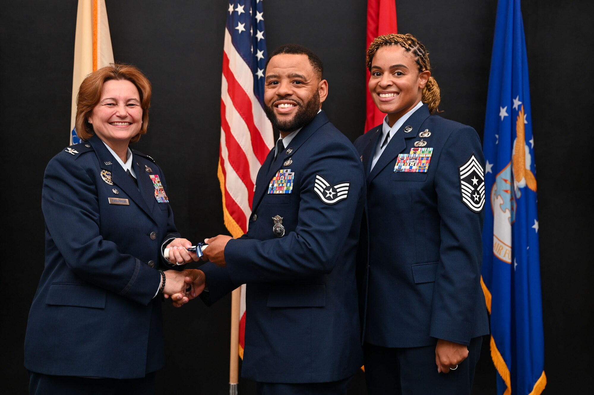U.S. Air Force Col. Angelina Maguinness, 17th Training Wing commander, presents Staff Sgt. Keith Ferguson, 17th Security Forces Squadron military working dog trainer, with a diploma from the Community College of the Air Force at a CCAF graduation in the Powell Event Center, Goodfellow Air Force Base, Texas, June 21, 2024. The 52 graduates gained their associate degree through hard work and dedication. (U.S. Air Force photo by Airman 1st Class Evelyn J. D’Errico)