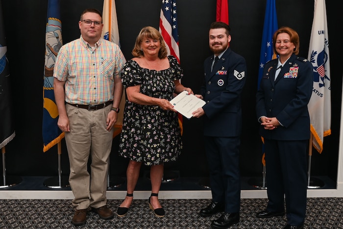Relatives of the late U.S. Air Force Col. (Ret.) Charles Powell, former 17th Training Wing commander, present the Powell Warrior Award to Staff Sgt. Joshua Elrod, 316th Training Squadron instructor, at a Community College of the Air Force graduation in the Powell Event Center, Goodfellow Air Force Base, Texas, June 21, 2024. The award is presented to those who choose to continue their education. (U.S. Air Force photo by Airman 1st Class Evelyn J. D’Errico)