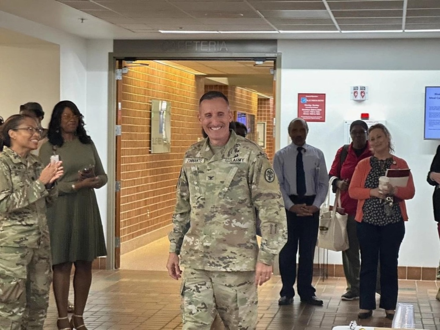 WAMC Commander, Col. David Zinnante walks out of the Weaver auditorium into a heartfelt surprise tribute to him by some of the Patient and Family Partnership Council members and WAMC staff following their monthly meeting.