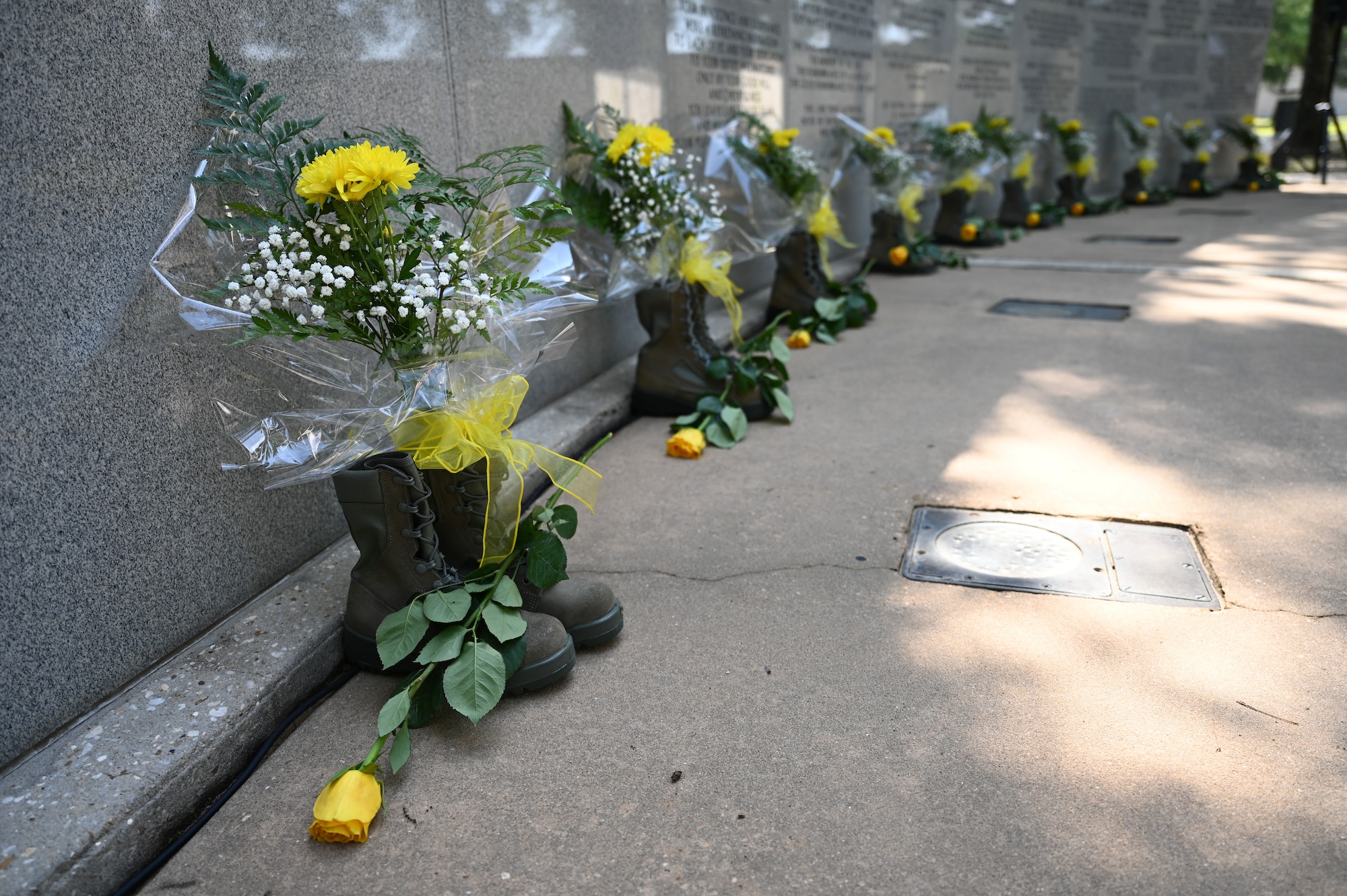 Combat boots and yellow flowers representing those who lost their lives are displayed during the 28th Annual Khobar Towers Memorial Ceremony at Eglin Air Force Base, June 25, 2024.