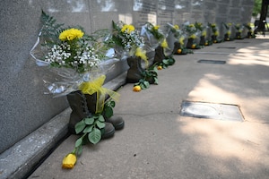 Combat boots and yellow flowers representing those who lost their lives are displayed during the 28th Annual Khobar Towers Memorial Ceremony at Eglin Air Force Base, June 25, 2024.