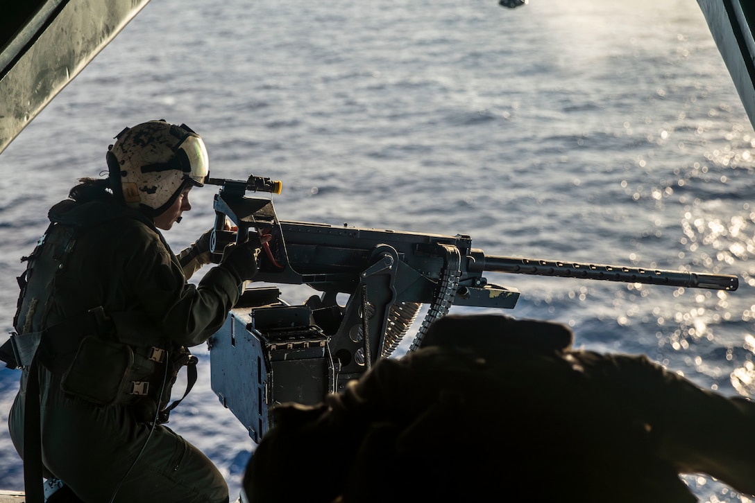 U.S. Marine Corps Sgt. Kaylee Cason, an aerial observer assigned to Marine Medium Tiltrotor Squadron (VMM) 165 (Reinforced), 15th Marine Expeditionary Unit, scans for targets with a .50-caliber machine gun aboard a CH-53E Super Stallion attached to VMM-165 (Rein.), 15th MEU, during aerial gunnery live-fire training in the Pacific Ocean June 24, 2024. The amphibious transport dock USS Somerset (LPD 25) and embarked elements of the 15th MEU are conducting routine operations in the U.S. 7th Fleet area of operations. 7th Fleet is the U.S. Navy's largest forward-deployed numbered fleet, and routinely interacts and operates with allies and partners in preserving a free and open Indo-Pacific region. (U.S. Marine Corps photo by Sgt. Patrick Katz)
