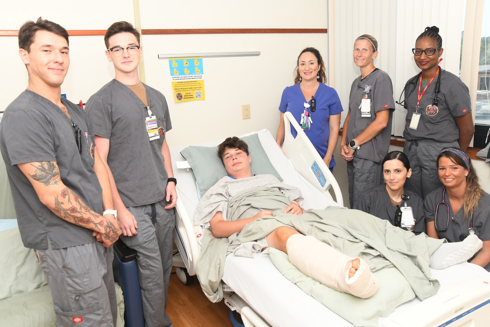 Blayne Brown is surrounded by his team of health care professionals at Naval Medical Center Camp Lejeune on June 25, 2024. Brown was transported to the NMCCL Trauma Center from North Topsail Beach on June 23 after suffering extensive wounds to his right leg from a shark bite. Brown was cared for by a team of providers at NMCCL; he will soon travel home to West Virginia to complete recovery.