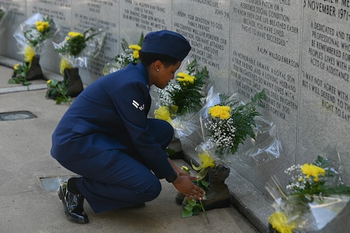 U.S. Air Force Airman 1st Class Bobbie Mills, 60th Fighter Squadron aircrew flight equipment apprentice, places a rose to honor a fallen airman during the Khobar Towers memorial ceremony at Eglin Air Force Base, Florida, June 25, 2024.