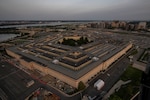 A building with five sides is photographed from above at twilight.