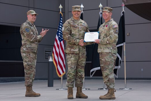  U.S. Space Force Col. David A. Pheasant, right, is awarded The Legion of Merit from Lt. Gen. David N. Miller, Jr., Space Operations Command commander, center. The award highlights Pheasant’s exceptional meritorious conduct as a commander of DEL 8 from July 2022 to June 24, 2024. (U.S. Space Force photo by 1st Lt. Danielle Rose)