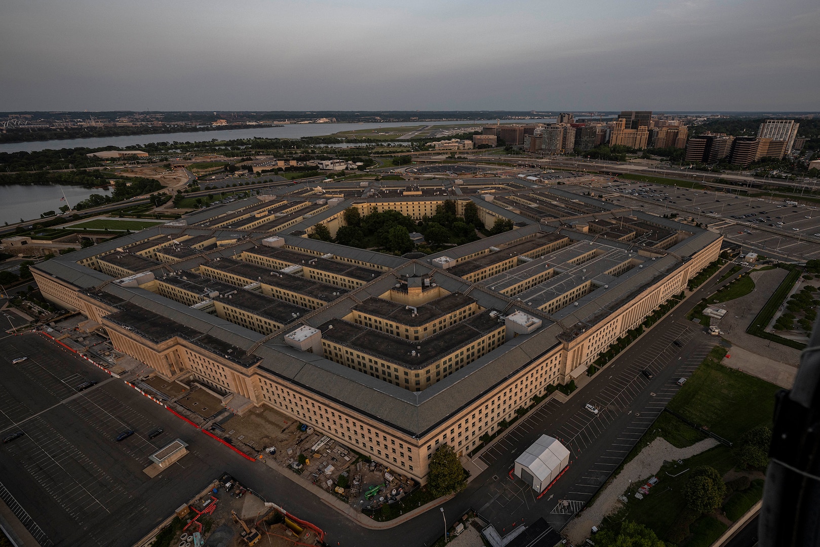 A building with five sides is photographed from above at twilight.