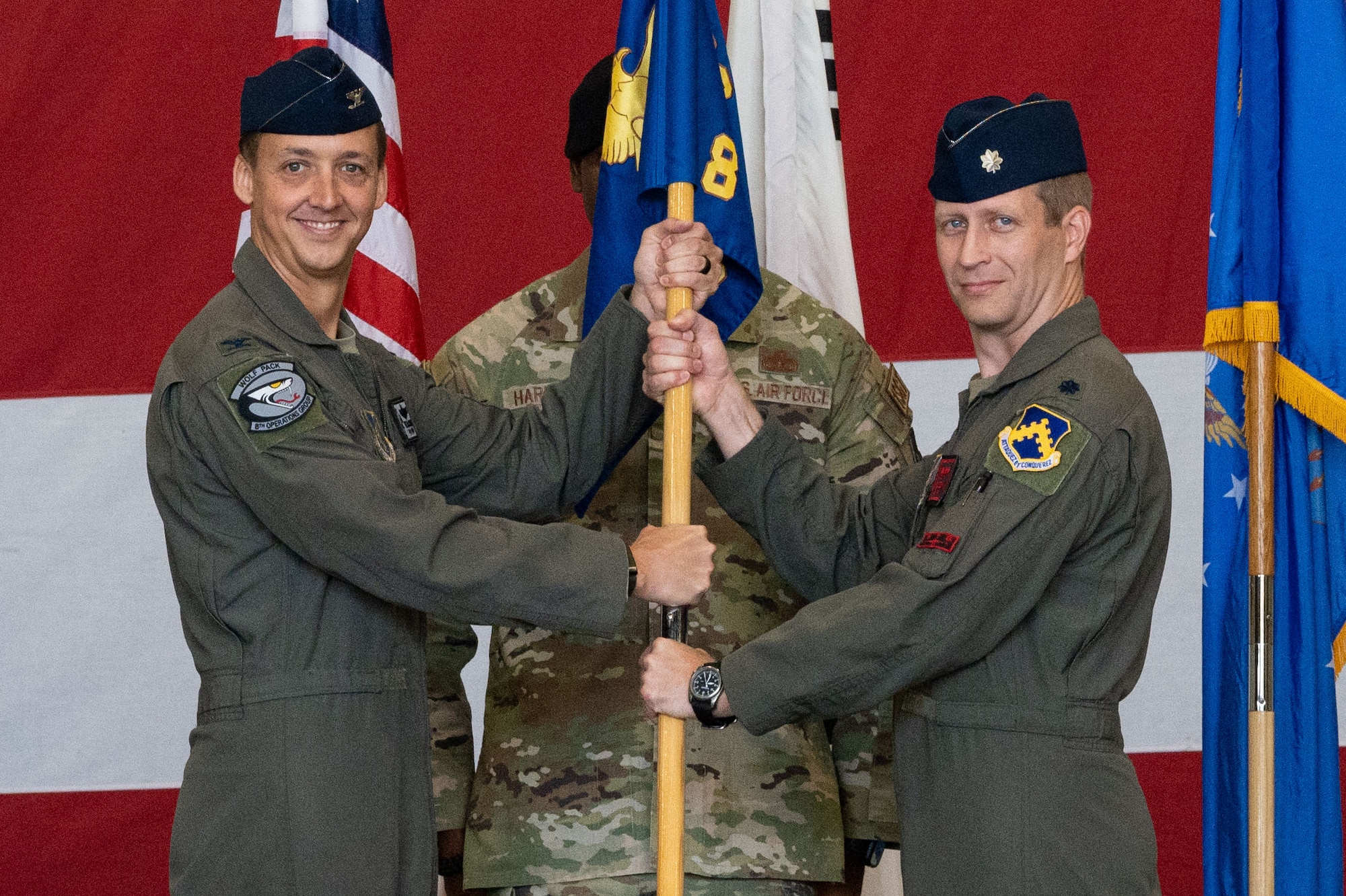 Col. Michael McCarthy, left, 8th Operations Group commander, passes the 8th Operations Support Squadron guidon to Lt. Col. Mark Jaszczak, 8th OSS incoming commander, during the 8th OSS change of command ceremony.
