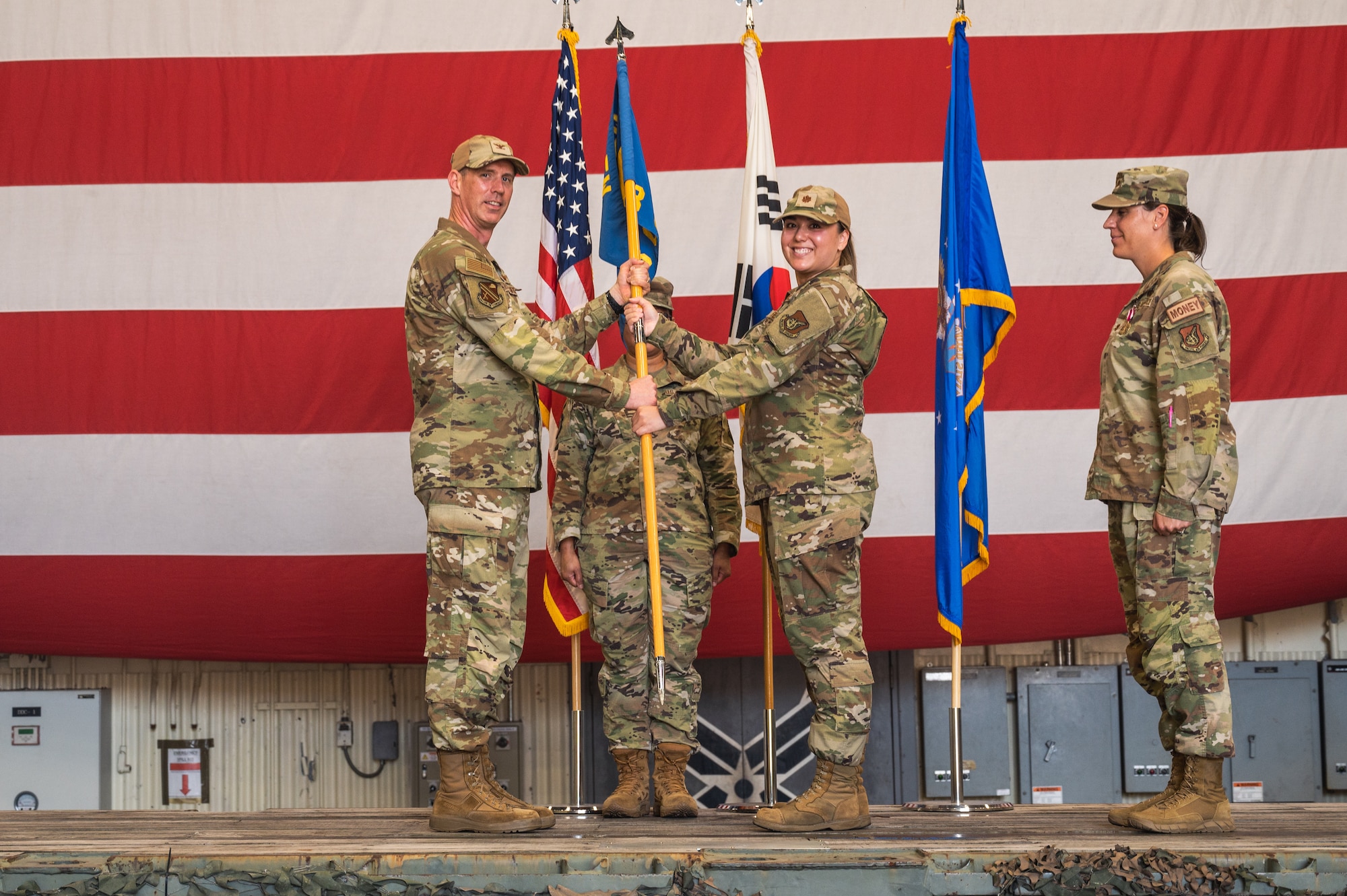 U.S. Air Force Col. Peter Kasarskis, 8th Fighter Wing commander, passes the guidon to Maj. Mary Fehrs, 8th Comptroller Squadron incoming commander, during the 8th CPTS change of command ceremony.