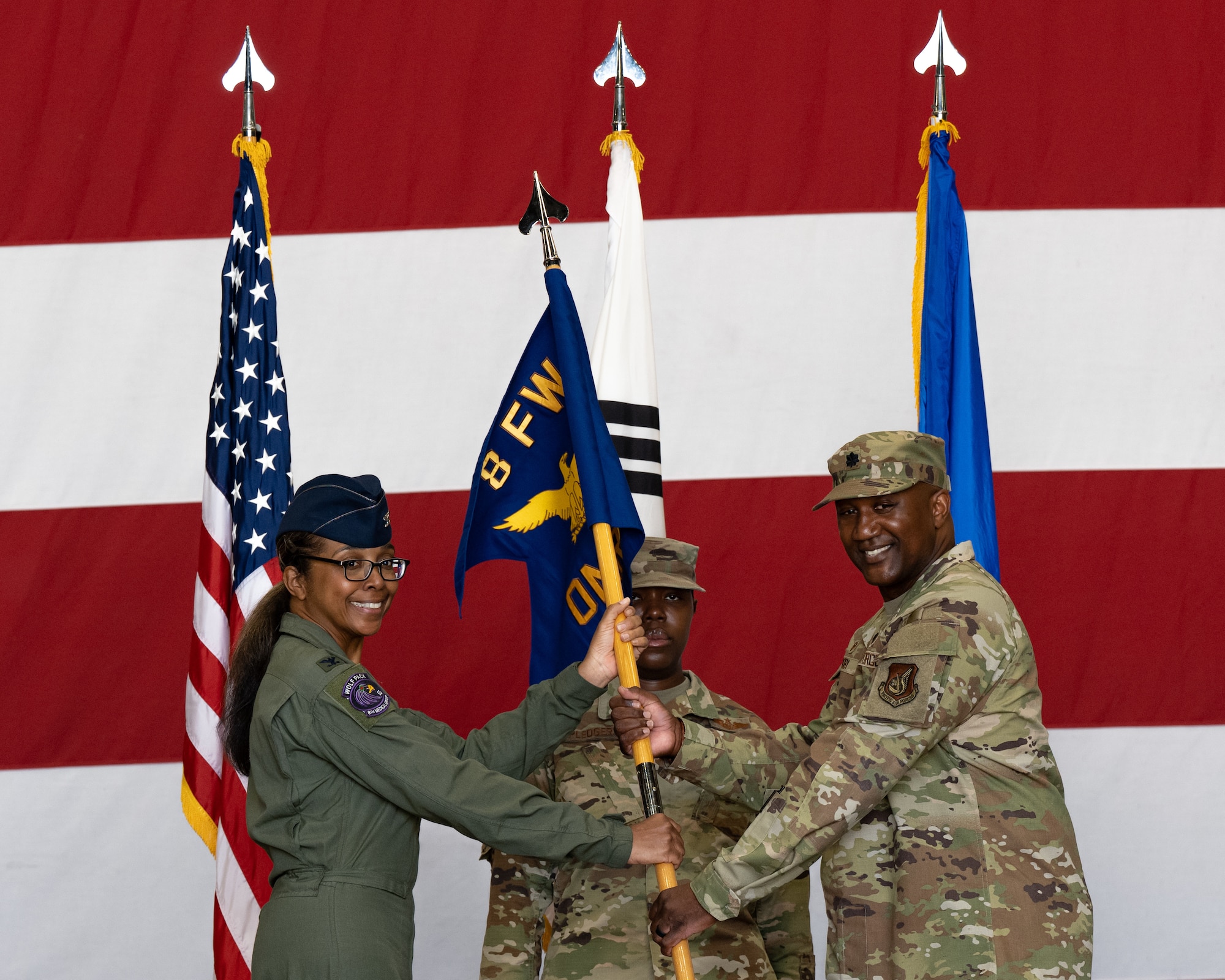 U.S. Air Force Col. Elizabeth Anderson-Doze, 8th Medical Group commander, passes the 8th Operational Medical Readiness Squadron guidon to Lt. Col. Alfred Doby, 8th OMRS incoming commander, during the 8th OMRS change of command ceremony.