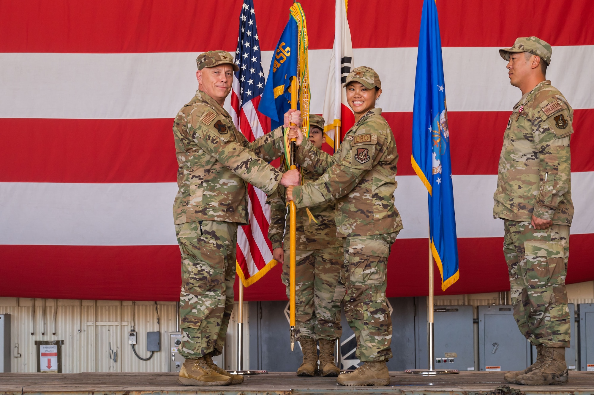 U.S. Air Force Maj. Micah Telmo, 8th Logistics Readiness Squadron incoming commander, receives the guidon from Col. Christopher Lacek, 8th Mission Support Group commander, during the 8th LRS change of command ceremony.