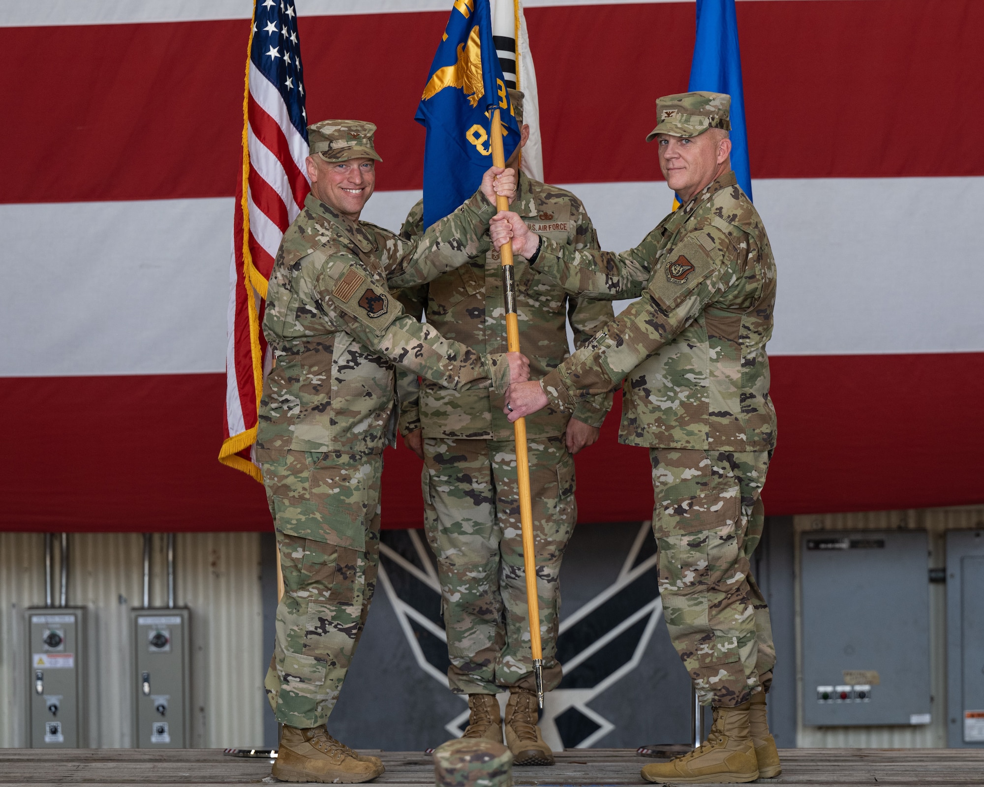 Col. Matthew Gaetke, left, 8th Fighter Wing commander, passes the 8th Maintenance Group guidon to Col. Casey Crabill, right, 8th MXG incoming commander, during the 8th MXG change of command ceremony.