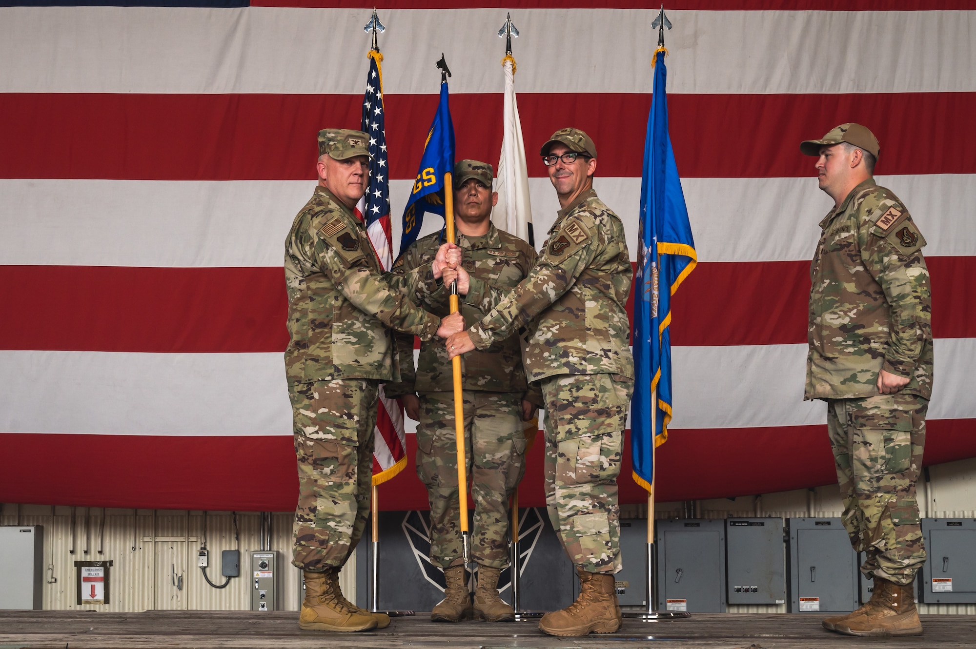 From left, U.S. Air Force Col. Casey Crabill, 8th Maintenance Group commander, passes the squadron guidon to Maj. Adam Marthaler, 35th Fighter Generation Squadron incoming commander, during the 35th FGS change of command ceremony.