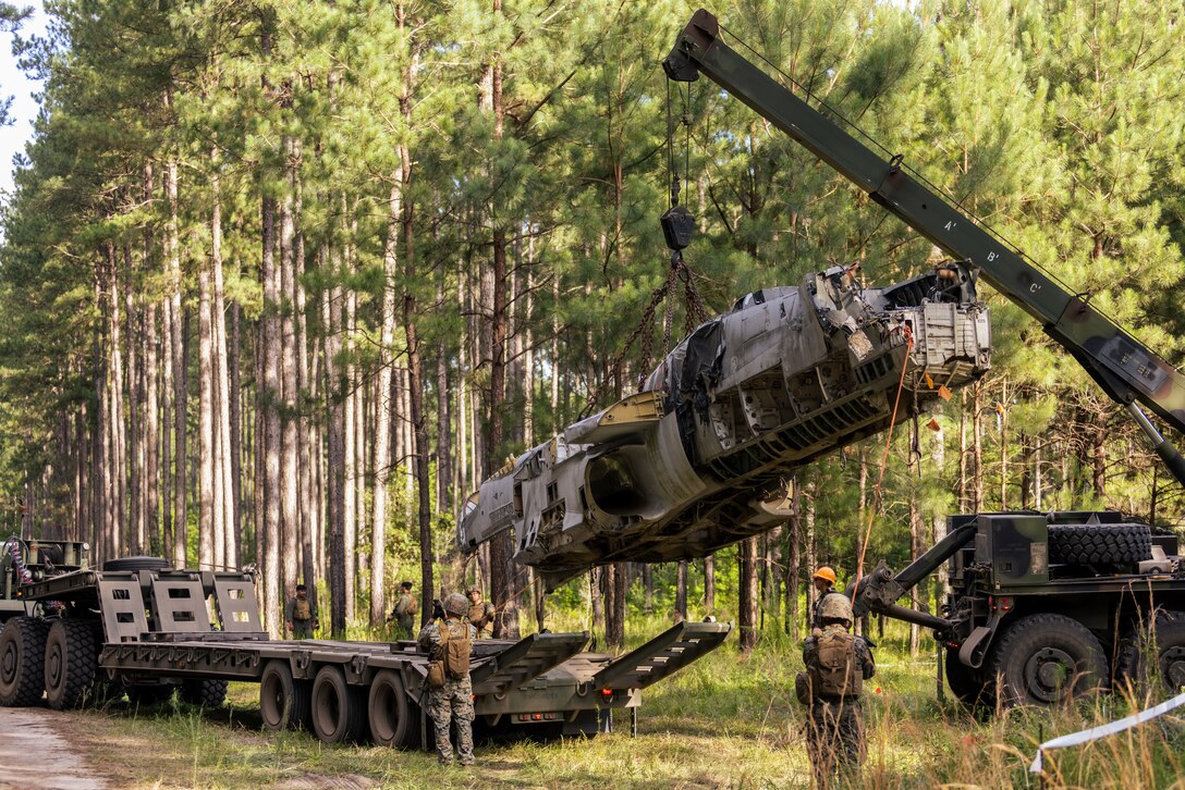 U.S. Marines with Marine Wing Support Squadron (MWSS) 273, Marine Air Control Group (MACG) 28, 2nd Marine Aircraft Wing (MAW), lift a damaged aircraft during an aircraft salvage and recovery scenario at Townsend Bombing Range, Georgia, June 12, 2024. MWSS-273 conducted training during a field exercise to sustain their ability to ensure key assets do not fall into enemy hands and proper medical care is given to injured personnel, enabling them to help maintain 2nd MAW’s combat readiness. (U.S. Marine Corps photo by Lance Cpl. Kyle Baskin)