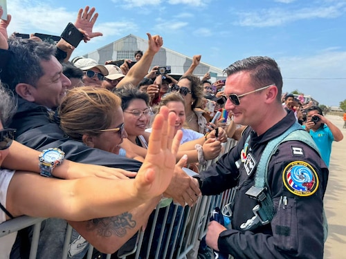 Captain Hiester shakes hands with a crowd of people.