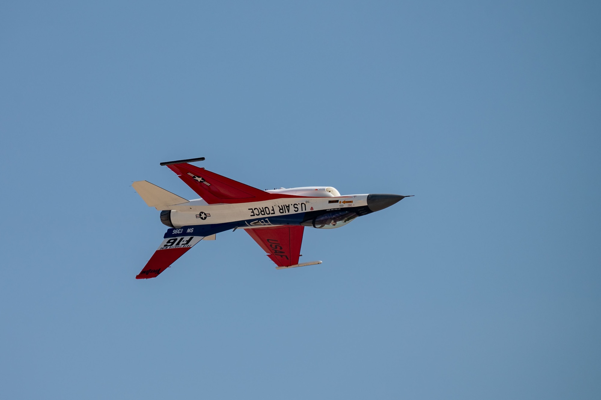 A photo of an F-16 flying upside down.