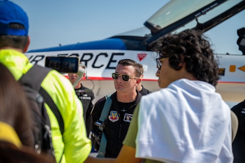 Captain Hieser speaks to the media in front of an F-16.