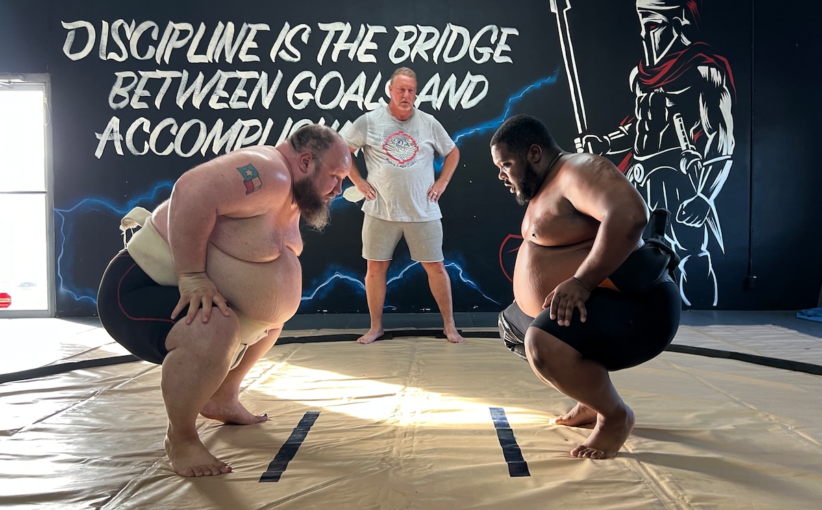 Scriven and Baccus in the squat position with hands on knees