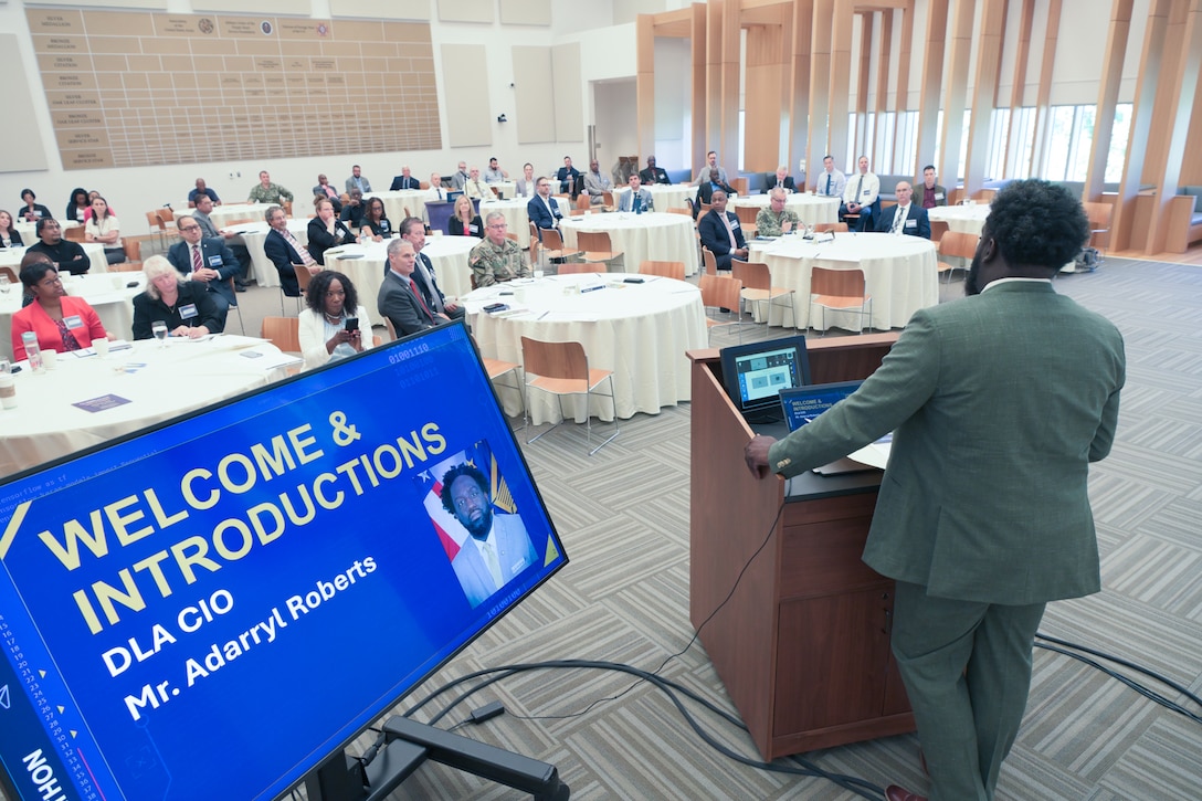 Defense Logistics Agency Chief Information Officer Adarryl Roberts behind podium speaking to tables of guests