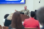 Defense Logistics Agency Director Lt. Gen. Mark Simerly behind podium speaking to Hackathon attendees