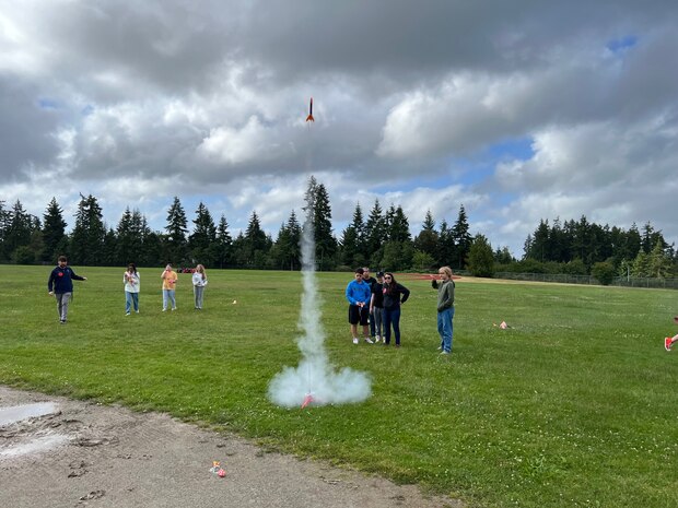 A group of students from Ridgetop Middle School’s ‘Introduction to Engineering’ course test launch a model rocket during an early-June event in Silverdale, Washington. Strategic Weapons Facility-Pacific (SWFPAC) Science, Technology, Engineering, and Math (STEM) program volunteers have supported four successful launches from 2023-2024, and volunteers ensure the safety of students during the rocket launches; assist with connecting launchers; fix faulty fuses; and answer questions about how rocket launches relate to SWFPAC’s real-world mission. SWPFAC is the command dedicated to assembling, maintaining, and storing TRIDENT II D5 Missiles and deploying them on fleet ballistic missile submarines (U.S. Navy Photo by Chani Wenning/Released)
