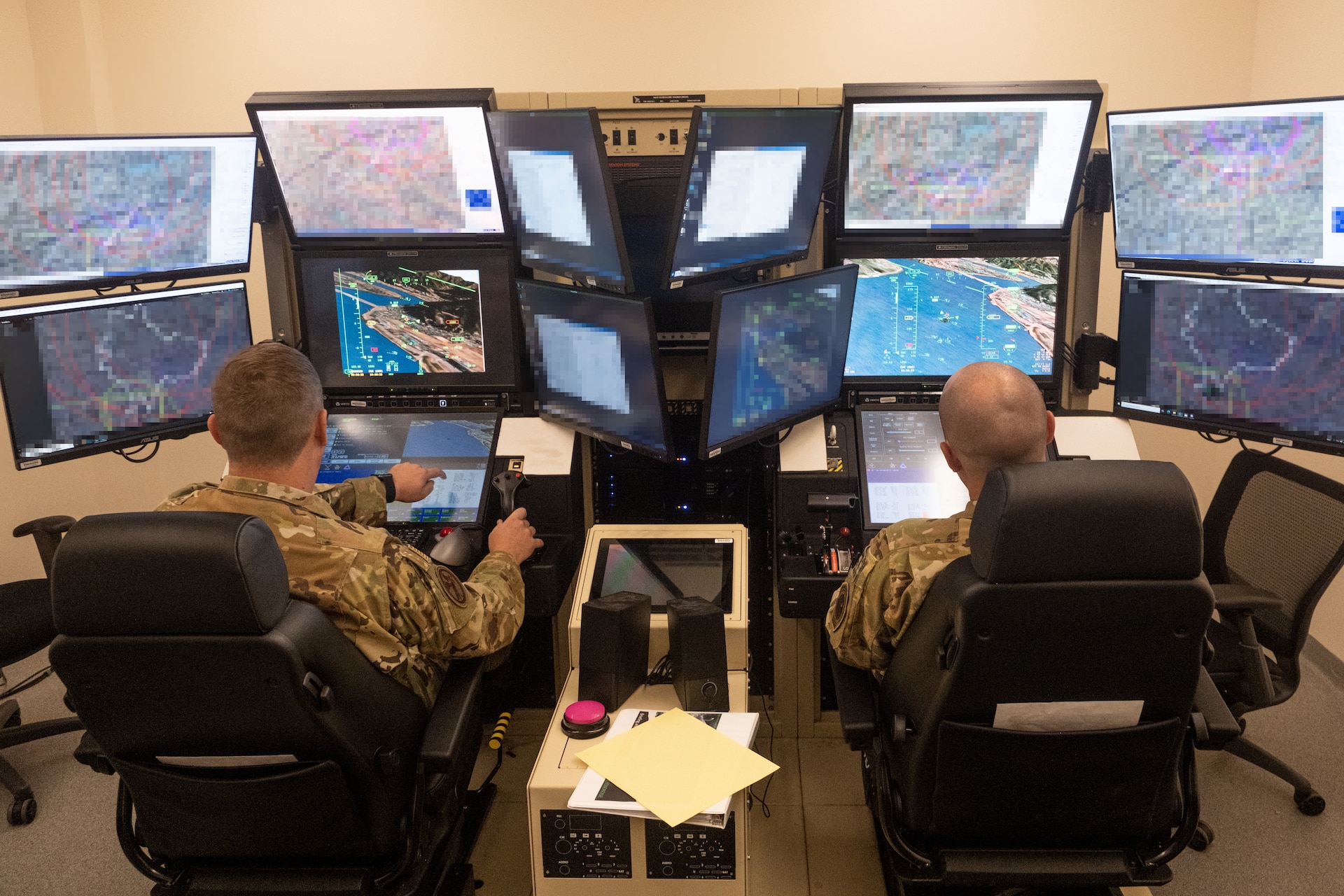 Two United States Air Force MQ-9 Reaper unmanned aerial system operators from the 103rd Attack Squadron, 111th Attack Wing, Pennsylvania Air National Guard, fly a simulated mission during exercise Reaper Smoke 2023 at Hancock Field Air National Guard Base in Syracuse, NY, Sep. 21. During the event more than 45 MQ-9 Reaper crews from across all three components of the U.S. Air Force put their skills to the test to see who among them was the “best of the best.” (U.S. Air National Guard photo by Alexander Rector) (This photo has been altered for security purposes by blurring display screens)